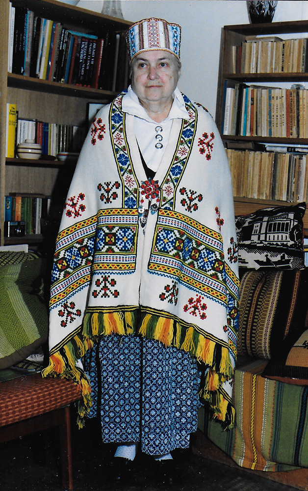 Ērika Zosārs Praulienas tautastērpā savās mājās Melburnā, Austrālijā, 20. gadsimta 80. gadu otrajā pusē. Ūves Zosāra dāvinājums. Foto no muzeja “Latvieši pasaulē” krājuma.